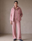Model wearing the blush pink cashmere cable knit hooded set with the blush pink cashmere cable knit puffer gilet with leather trim – Dolcie London