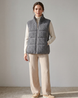Model wearing the grey cashmere cable knit down vest over an ivory roll-neck with beige cable knit trousers – Dolcie London