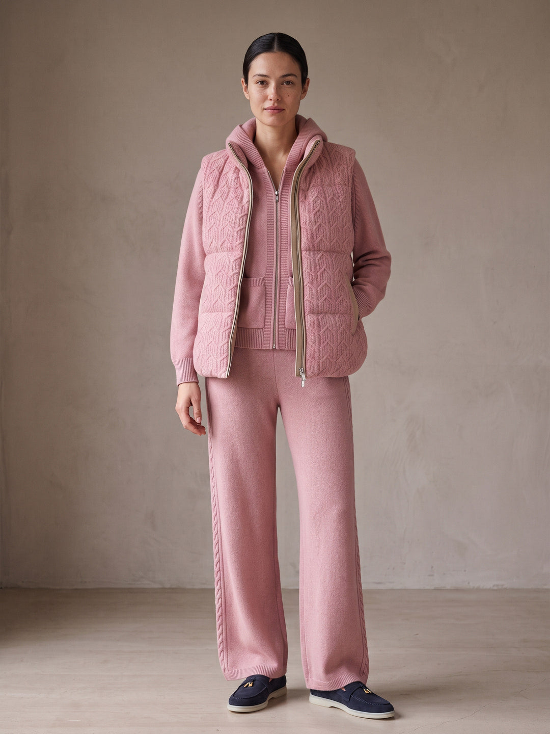 Model wearing the blush pink cashmere cable knit hooded set with the blush pink cashmere cable knit puffer gilet with leather trim – Dolcie London