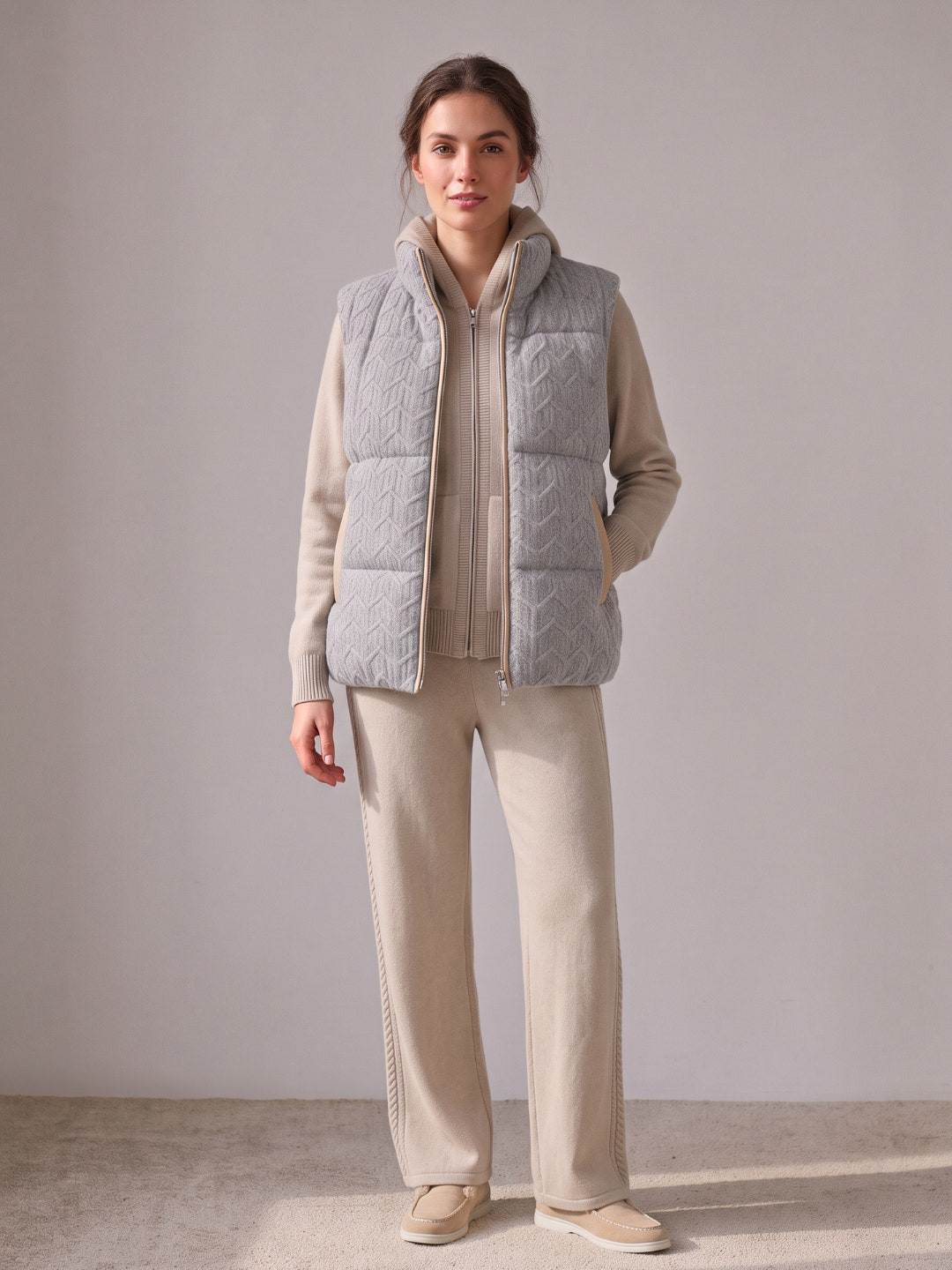 Model wearing the beige cashmere cable knit hooded set with the grey cashmere cable knit puffer gilet with leather trim – Dolcie London