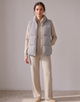 Model wearing the beige cashmere cable knit hooded set with the grey cashmere cable knit puffer gilet with leather trim – Dolcie London